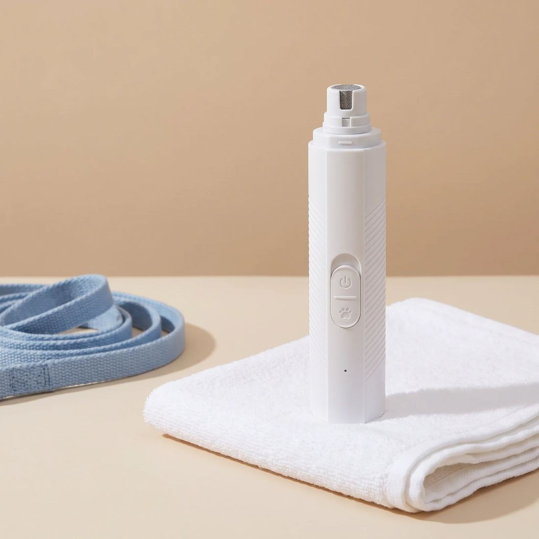 Trimvoro Aegis Pro Nail Grinder standing on a folded white towel next to a blue dog lead