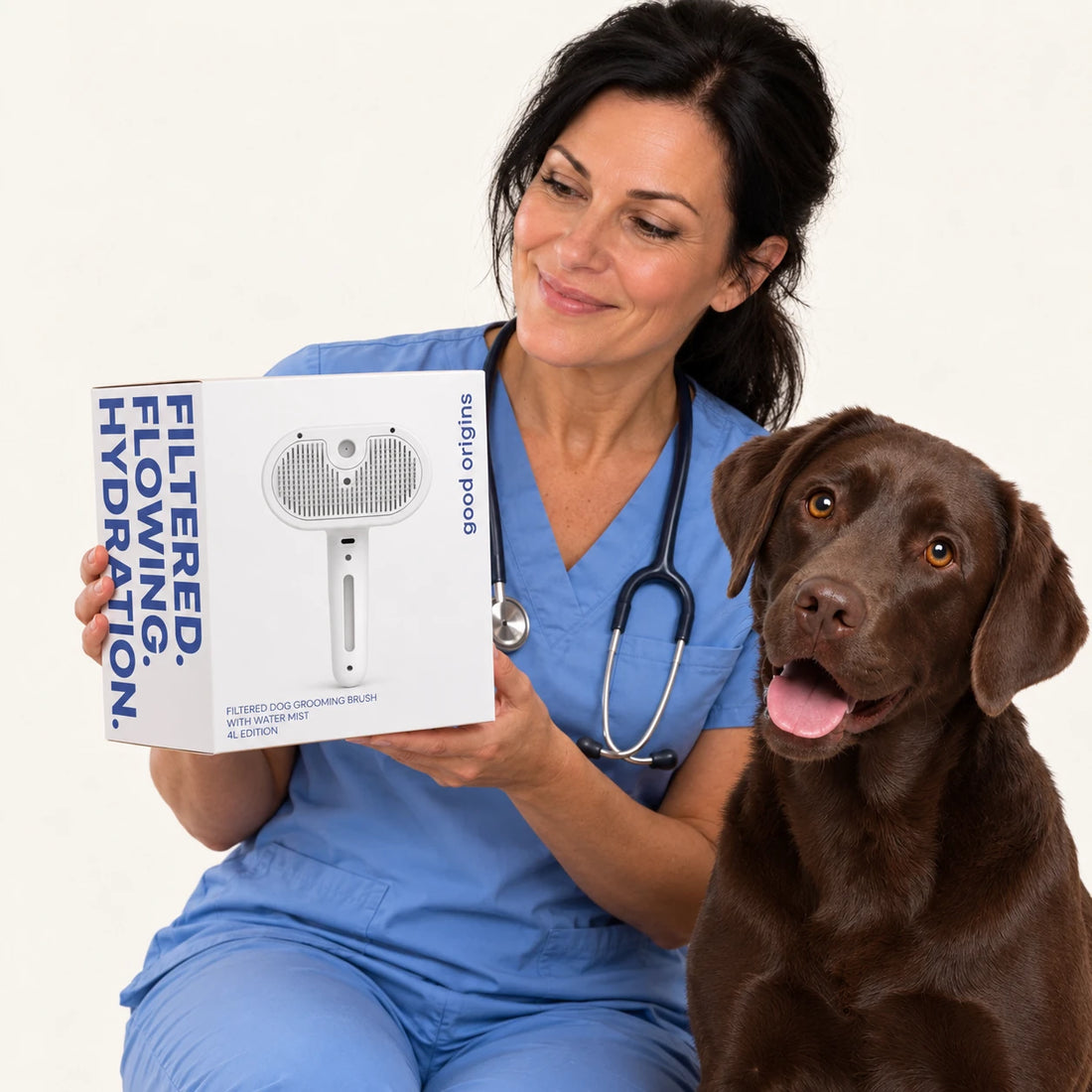 Smiling woman holding a white product box next to a chocolate Labrador