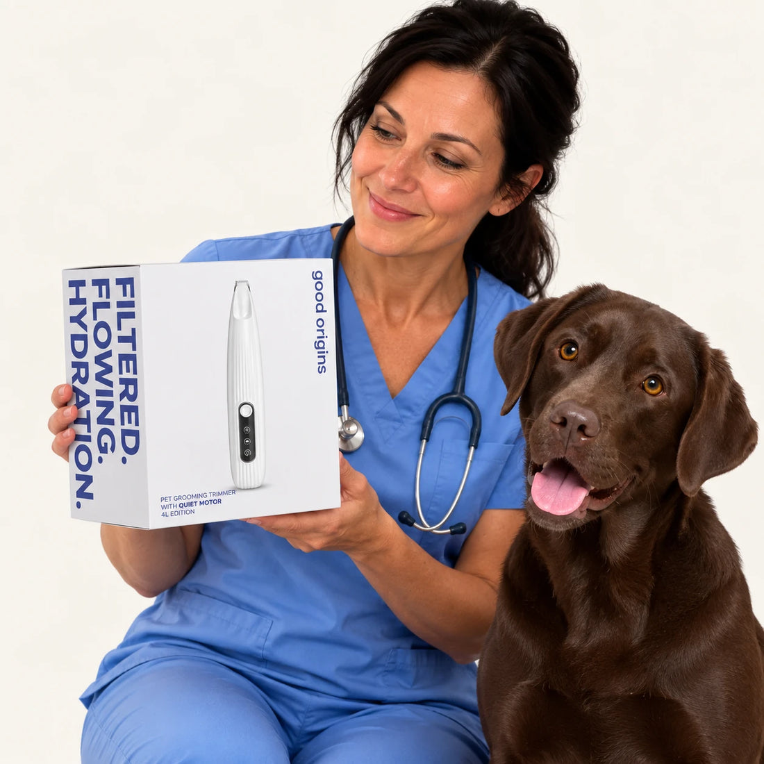 Smiling woman holding a white product box next to a chocolate Labrador